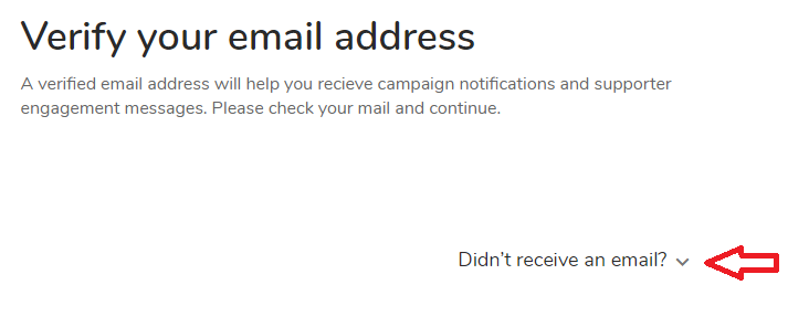 Black text on a white background. 'Verify your email address' is in large font at the top. Underneath, in smaller font, the text reads 'A verified email address will help you receive campaign notifications and supporter engagement messages. Please check your mail and continue.' At the bottom right of the screen, there is text reading 'Didn't receive an email?' next to a downward-pointing caret with a red arrow pointing to it.